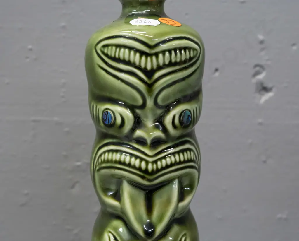 ceramic tiki liqueur bottle with paua eyes, Ti-Toki Auckland label, made in Aotearo impressed on base H-290 Image 1++