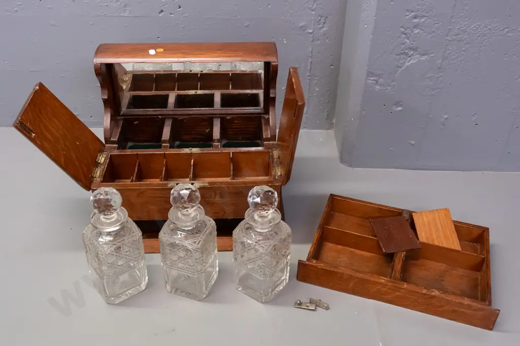 vintage oak tantalus with 3 decanters, lift-up lids exposing storage compartments, concealed latch for lower spring- Image 1++