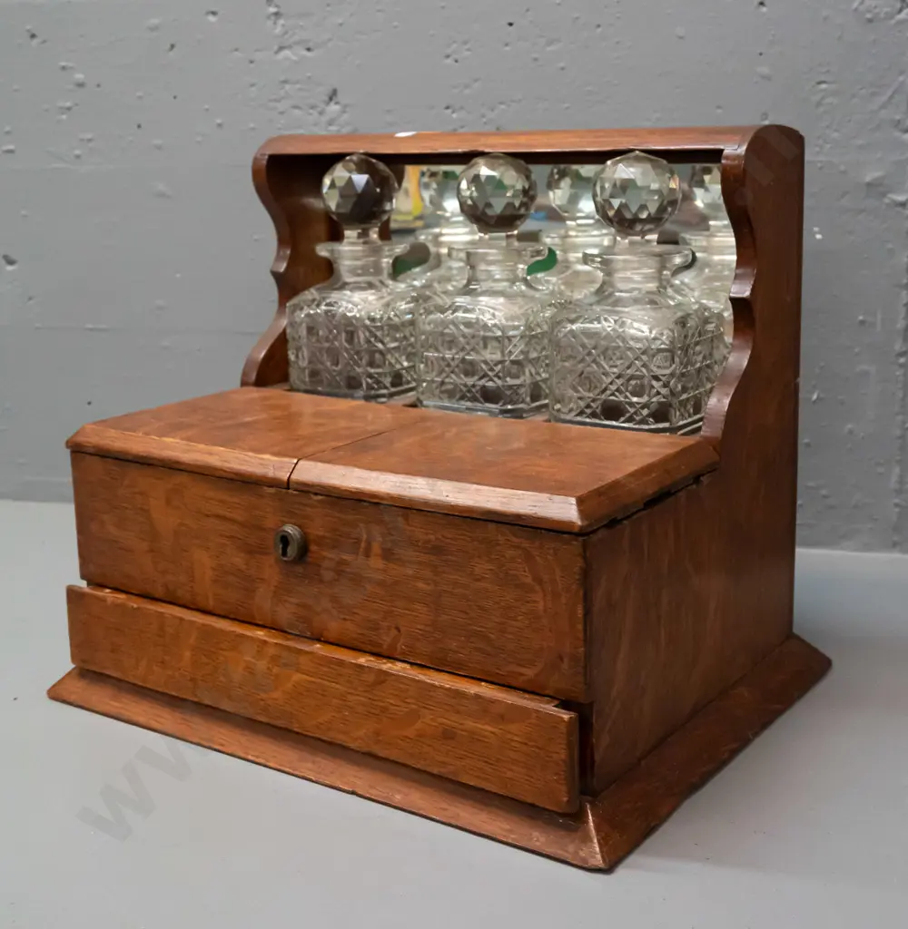 vintage oak tantalus with 3 decanters, lift-up lids exposing storage compartments, concealed latch for lower spring- Image 1++