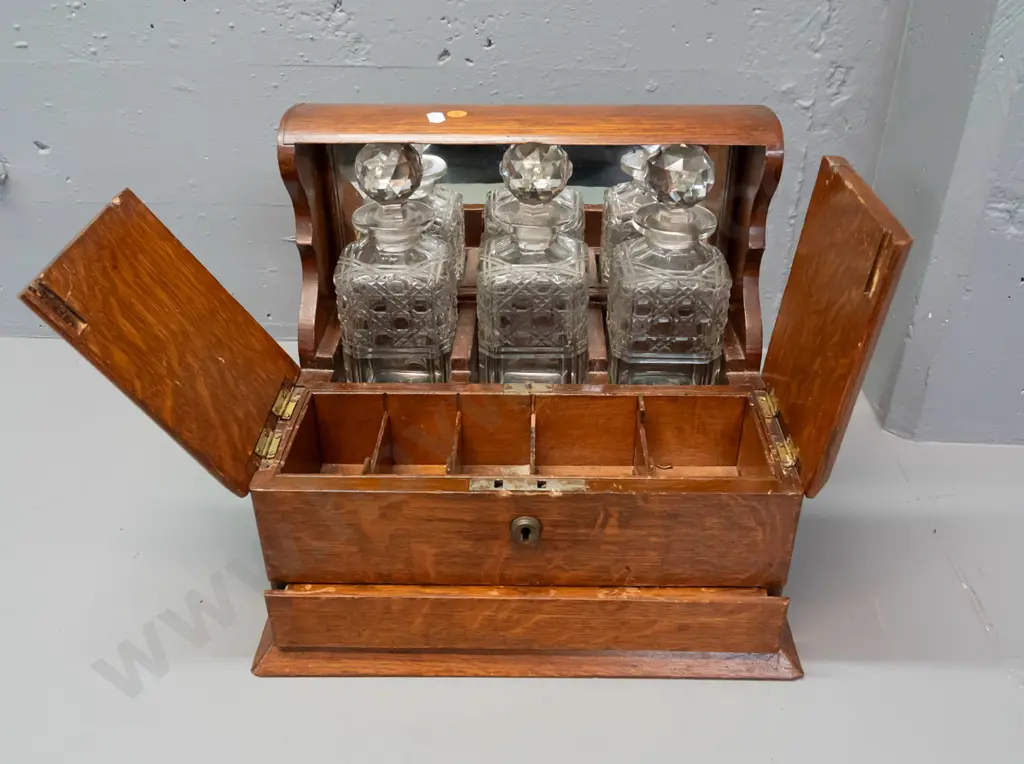 vintage oak tantalus with 3 decanters, lift-up lids exposing storage compartments, concealed latch for lower spring- Image 1++