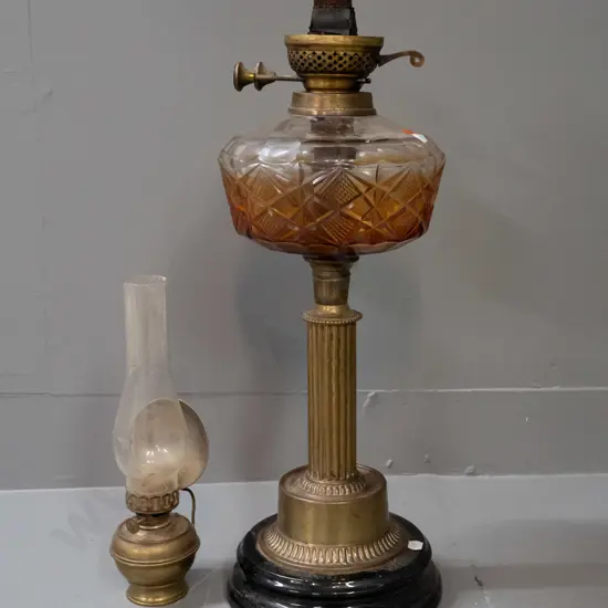 2 vintage kerosene lamps - larger with fluted brass column, cut glass tank with residue, no chimney. Smaller brass lamp
