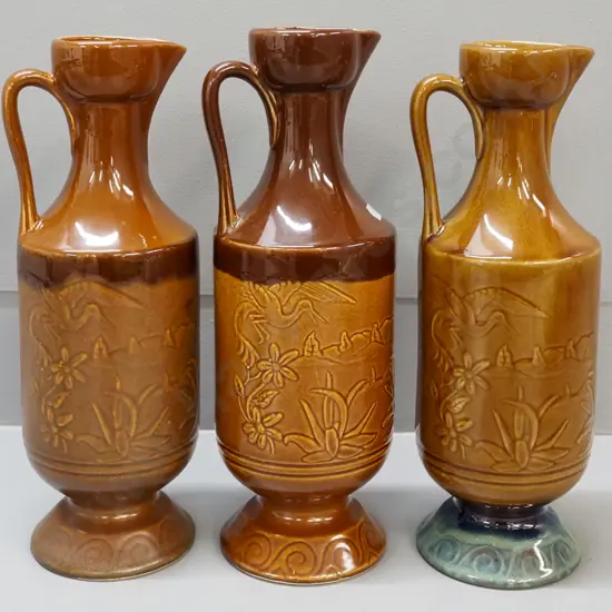 3 Orzel pottery NZ handled ewer jugs with raised floral and crane motifs - one has under-glaze fault on rim H-320
