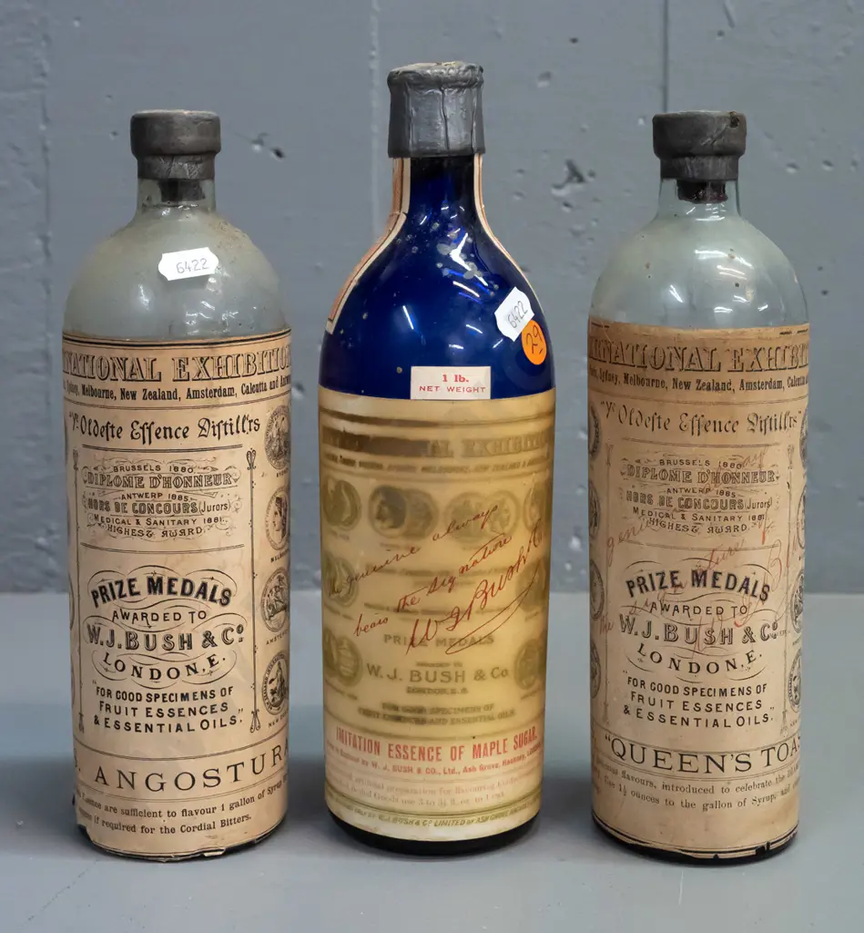 3 vintage glass bottles with labels and contents & WJ Bush & Co labels, one blue & 2 clear, metal cap seals H-250 Image 1++