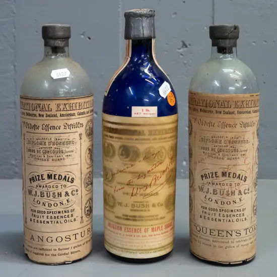 3 vintage glass bottles with labels and contents & WJ Bush & Co labels, one blue & 2 clear, metal cap seals H-250