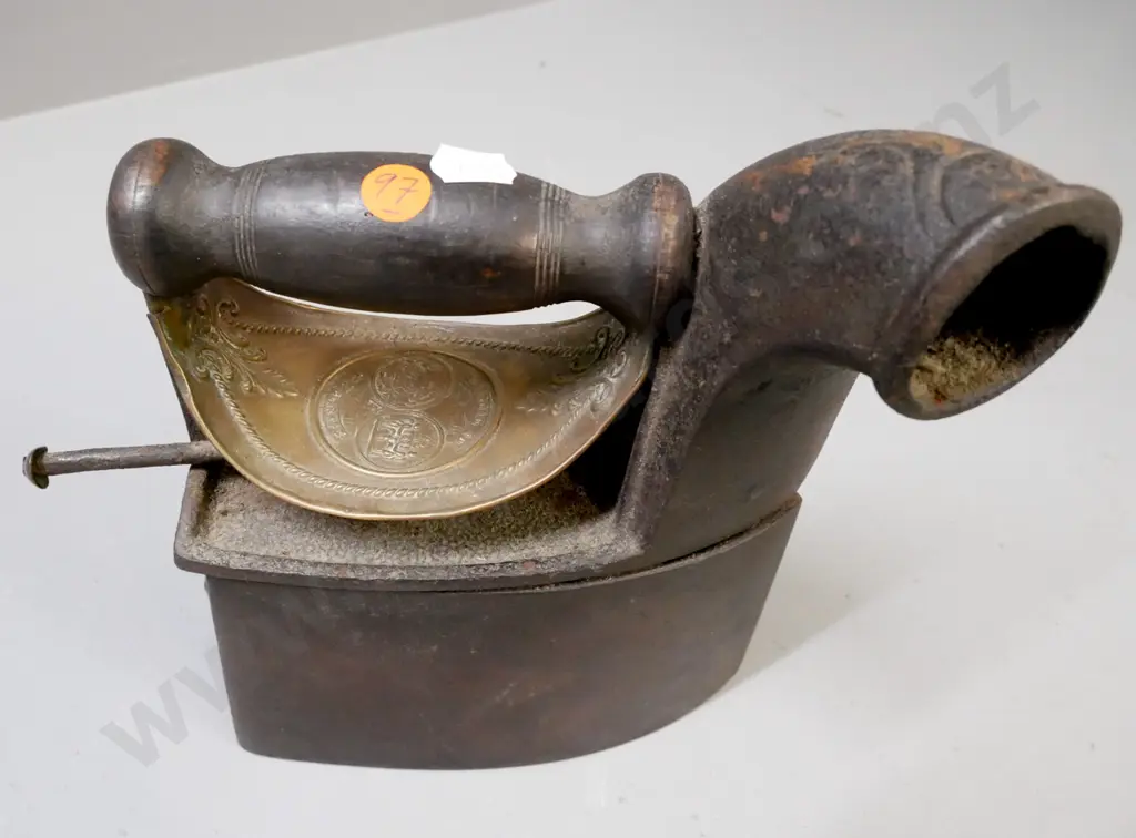 vintage cast metal coal iron on pierced trivet with embossed heat shield, turned wooden handle, back latch figurative. Image 1++