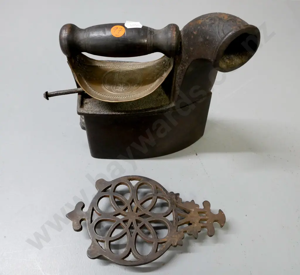vintage cast metal coal iron on pierced trivet with embossed heat shield, turned wooden handle, back latch figurative. Image 1++