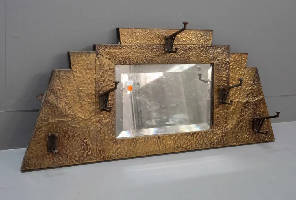 art deco beaten brass bevelled edge wall mirror with 5 hat / coat hooks. Tip broken off one hook, some desilvering. Image 1++
