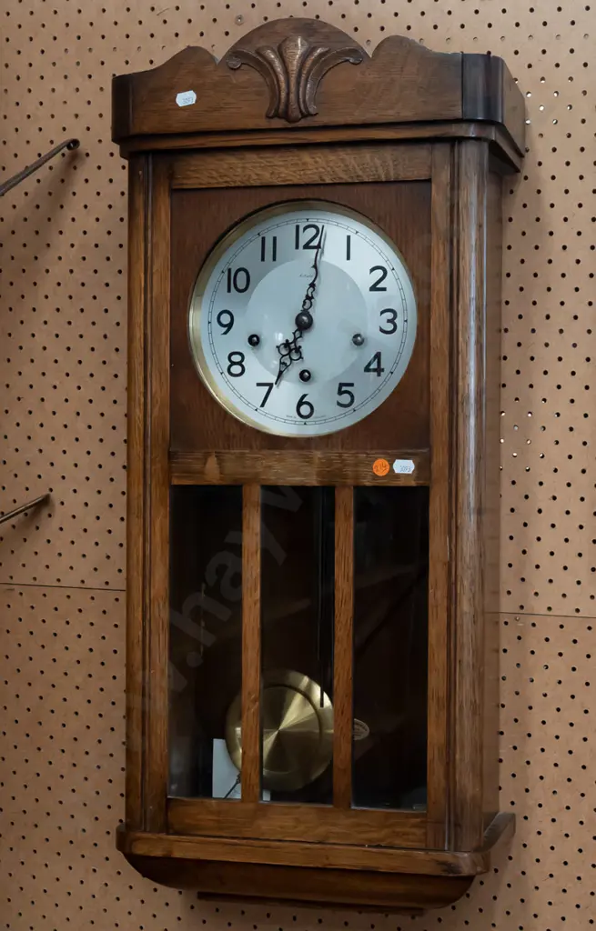 oak cased Art Deco chiming wall clock by Enfield, England. Glazed panels to door, brass pendulum and key. H-770 W-340 Image 1++
