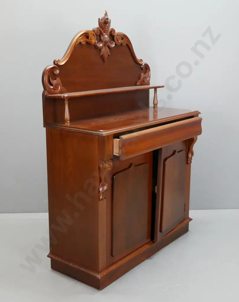 reproduction mahogany carved-back chiffonier with long top drawer and 2 panelled shield doors, upper shelf on turned Image 1++