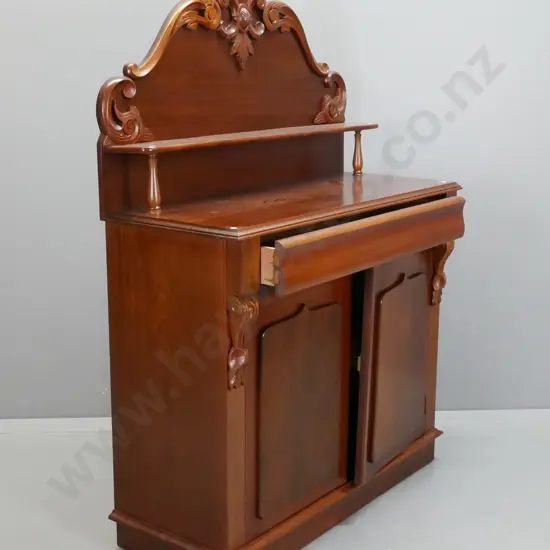 reproduction mahogany carved-back chiffonier with long top drawer and 2 panelled shield doors, upper shelf on turned