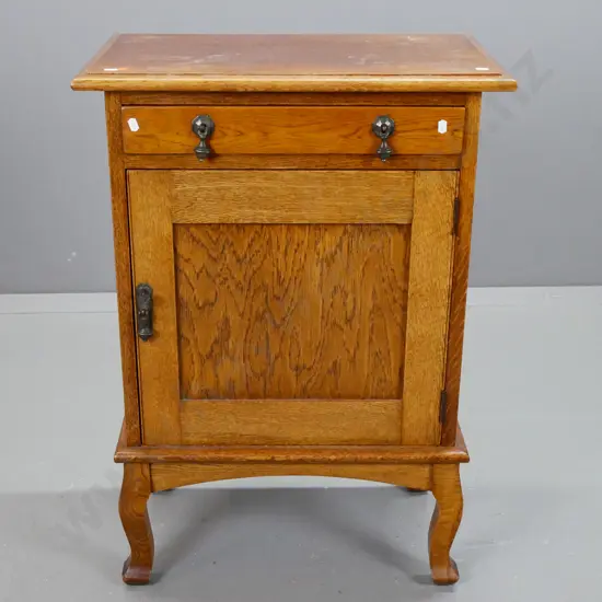 vintage oak cab leg bedside cupboard with 1 drawer, 1 door, one interior shelf, metal drop handles. Marks on top, borer