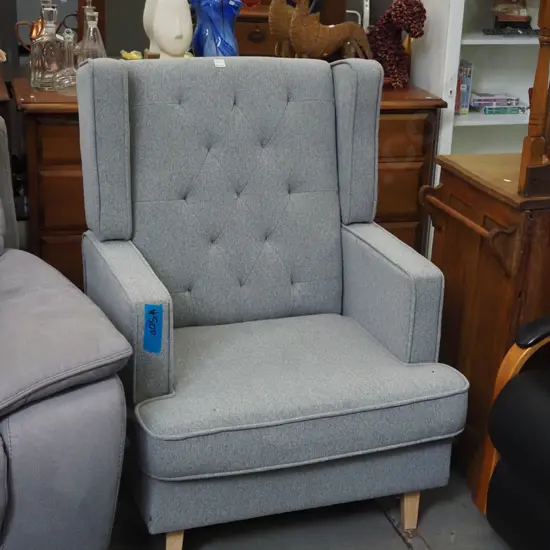 grey upholstered deep buttoned fireside chair