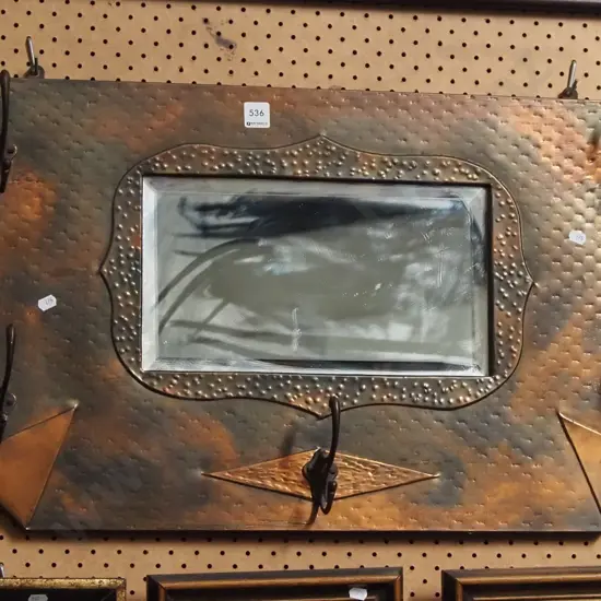 beaten copper hanging coat hooks and wall mirror