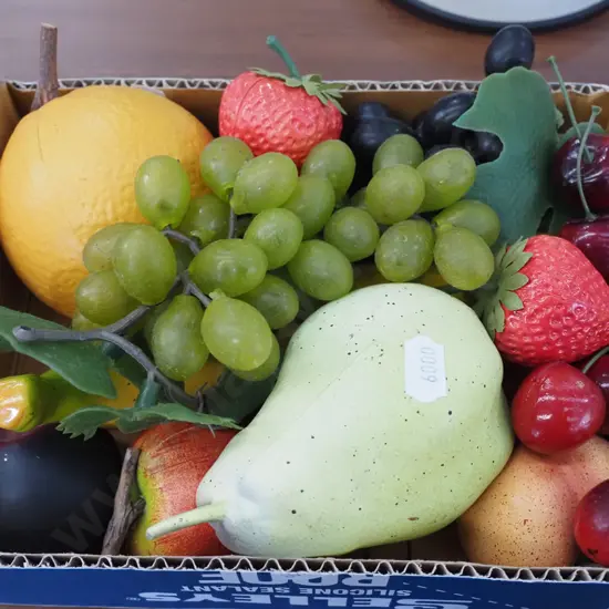 box of plastic  faux fruit