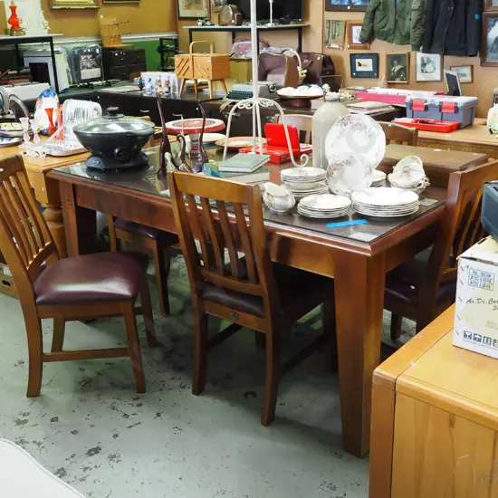 dark stained solid wood table with glass protective pane and matching chairs