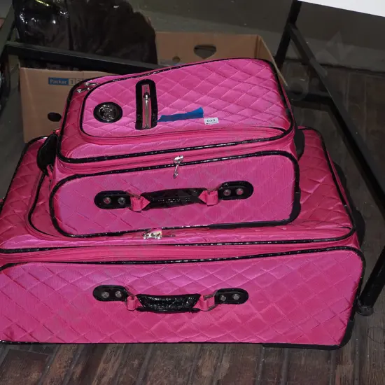 large and small pink suitcases