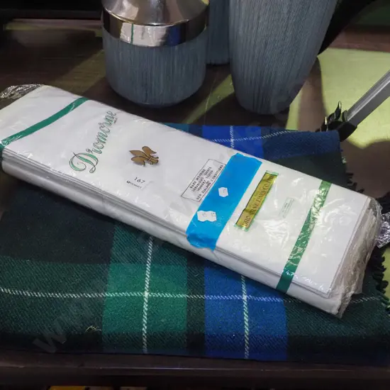 as new Irish linen sheets, checked woollen travel rug