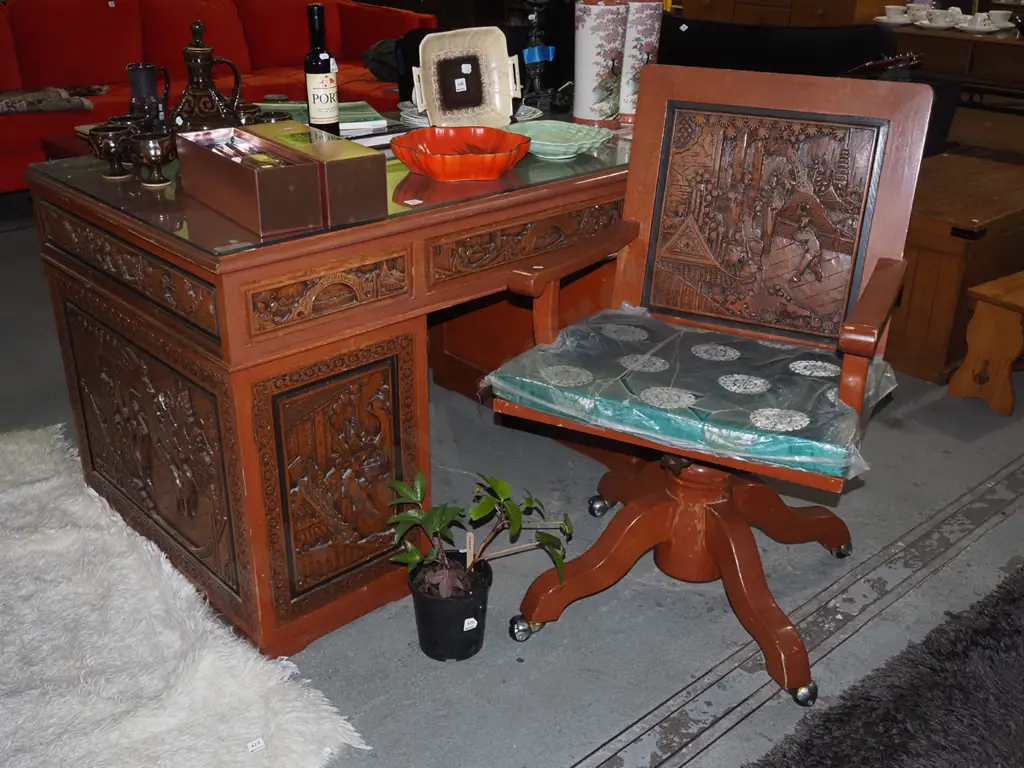 heavily carved Asian  6 drawer kneehole desk, 1 cupboard and matching chair Image 1++