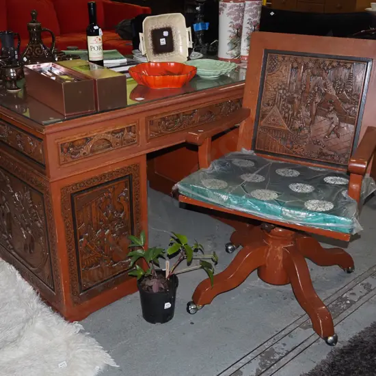 heavily carved Asian  6 drawer kneehole desk, 1 cupboard and matching chair