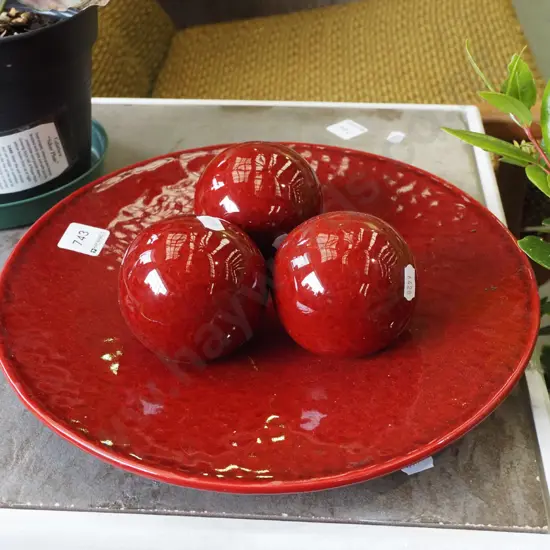 red ceramic plate with 3 matching balls