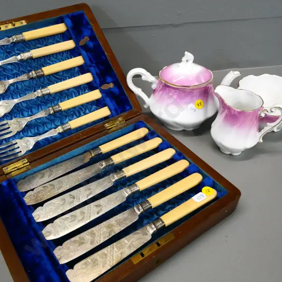 wood-cased engraved bone-handled fish set and a pink & white china 3-piece tea set, no maker's marks