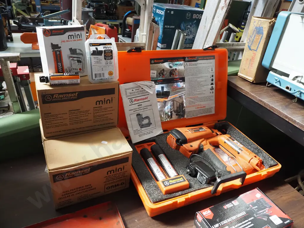 cased Ramset mini nail gun with 3 boxes of additional fuel cells and bars - batteries in office Image 1++