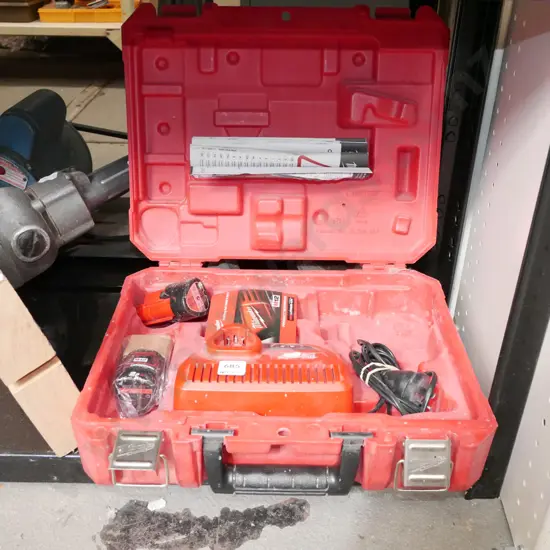 cased Milwaukee battery powered case with battery charger and 2 batteries - batteries in office
