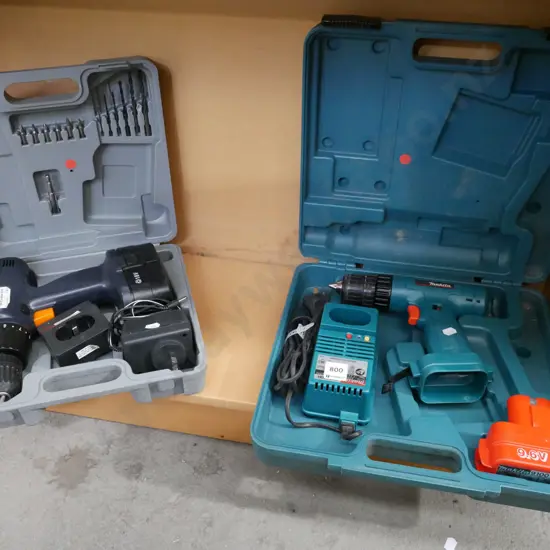 2x cased battery drills- batteries in office - red dots