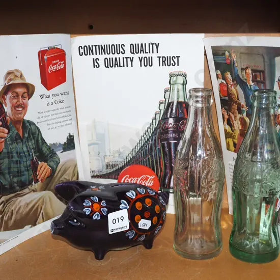 2x vintage Coke bottles, ceramic piggy bank, 3x Coca Cola advertisements