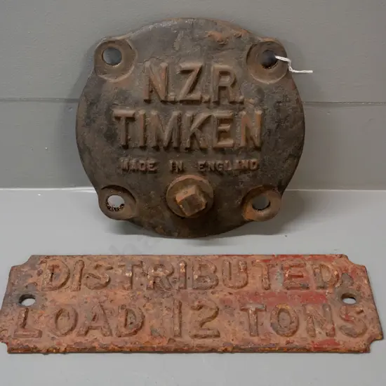 2 cast iron railway items - NZR Timken axle box cover plate and a corroded "Distributed Load 12 Tons" sign. Axle cover