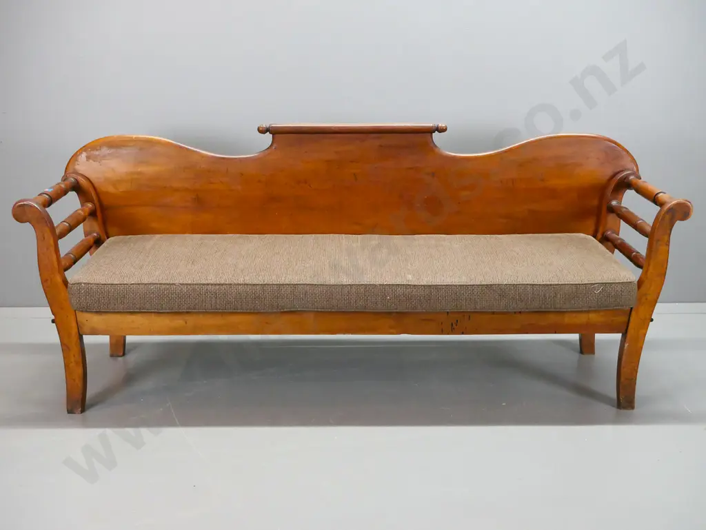 colonial rimu shearer's couch with rolling pin back, rolled and turned ends, foam squab on slatted base. Splits to Image 1++