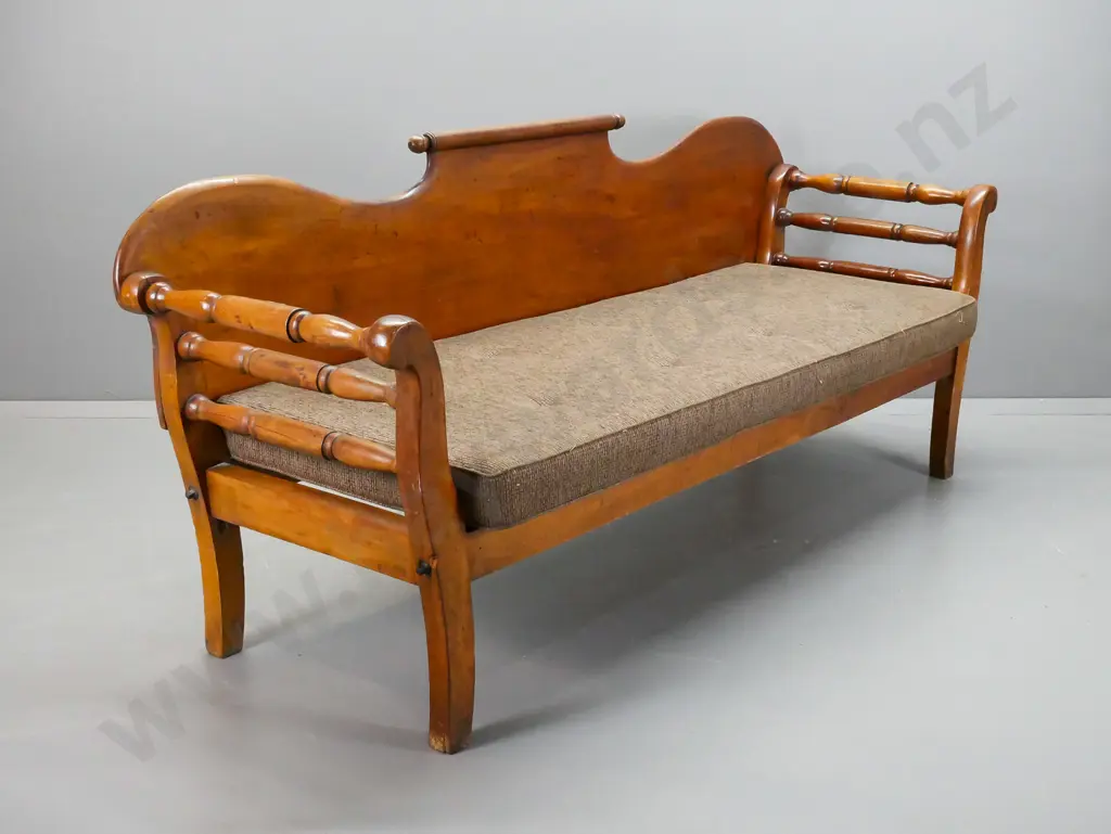 colonial rimu shearer's couch with rolling pin back, rolled and turned ends, foam squab on slatted base. Splits to Image 1++