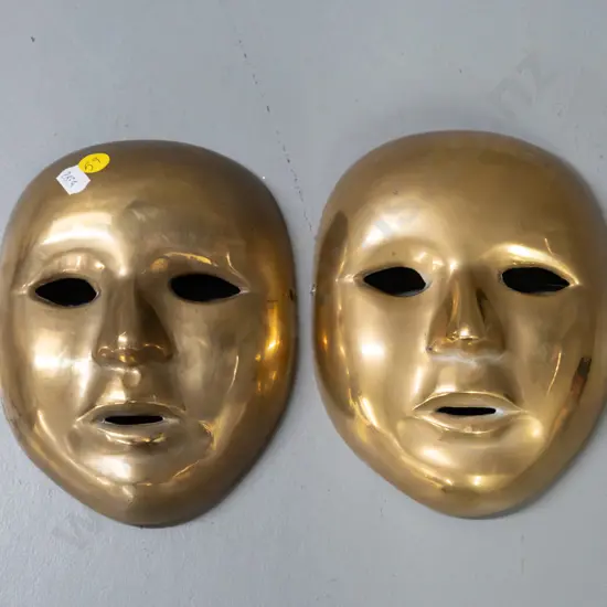 pair of cast brass ornamental wall masks. Hanging wire on one mask is broken. H-170 W-135
