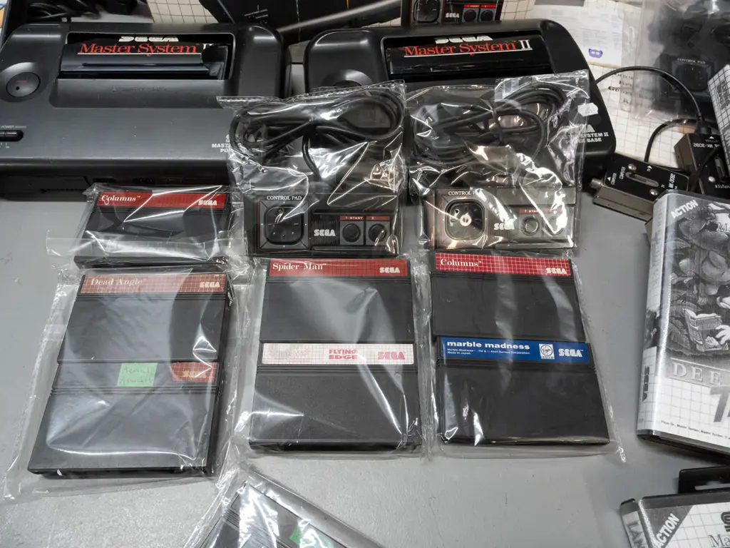 large Sega Master System II collection with 2 consoles, 2 handheld controllers, arcade pistol, numerous game cartridges Image 1++