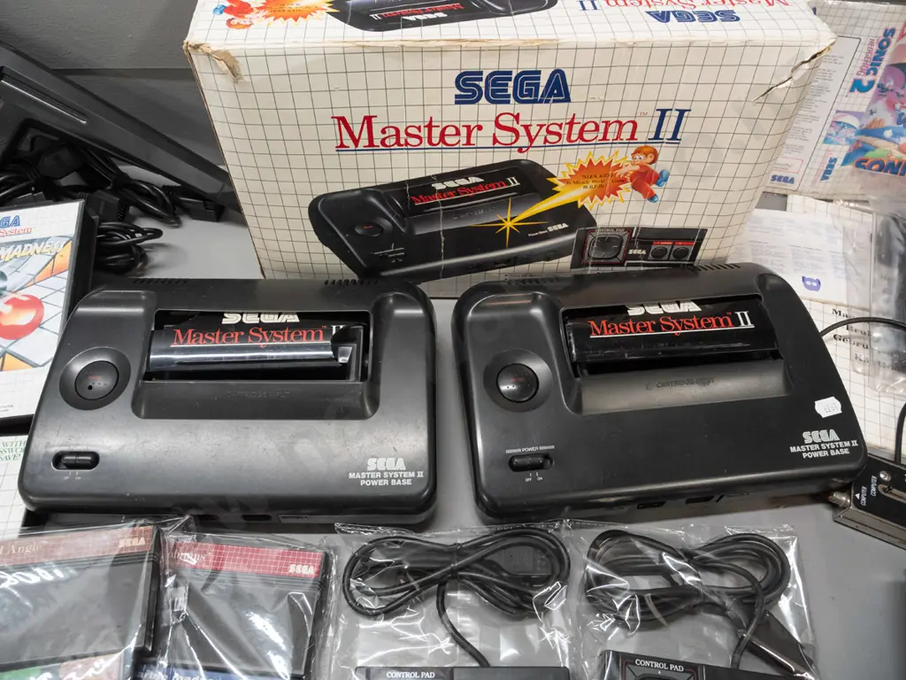 large Sega Master System II collection with 2 consoles, 2 handheld controllers, arcade pistol, numerous game cartridges Image 1++
