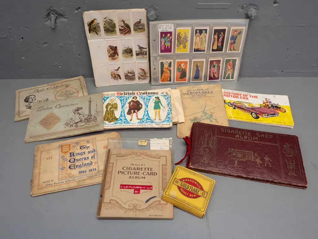 Assorted cigarette collector cards in sheets and albums, including a Wills cigarette box. Albums have partial contents Image 1++
