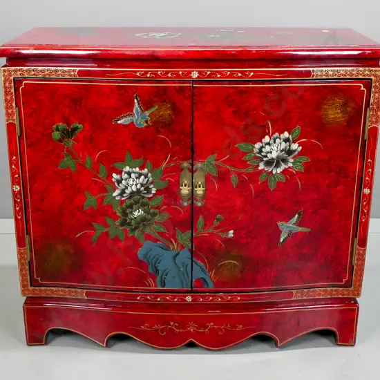Chinese 2 door cupboard with shaped front and plinth base, red painted finish with hand painted floral and bird motifs,