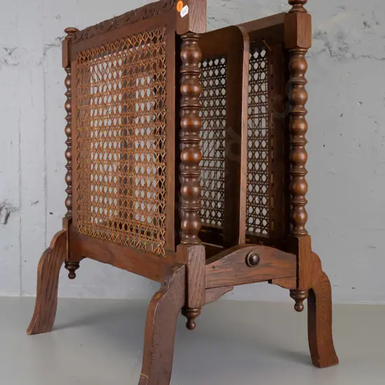 vintage dark-stained oak magazine rack with turned spindle ends and finials, 2 woven cane panels - minor damage to cane,