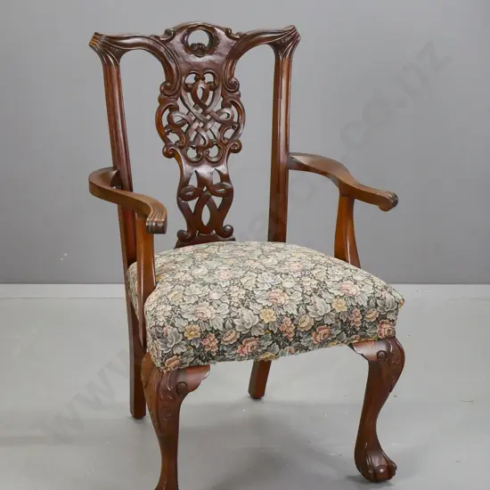 mahogany Chippendale-style open-arm chair with floral upholstered seat, carved and pierced back splat, claw & ball