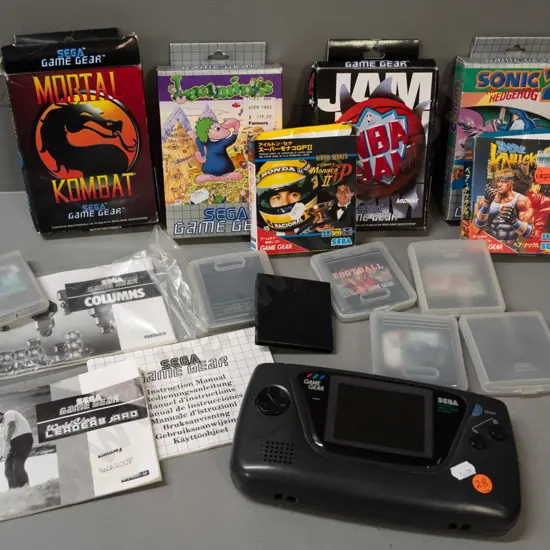 Sega Game Gear handheld game with 13 assorted cartridges, some boxed, some booklets - powers up, otherwise untested