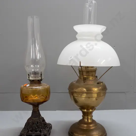 2 vintage kerosene lamps - brass with milk glass shade, one amber coloured tank on cast metal base, both with chimneys -