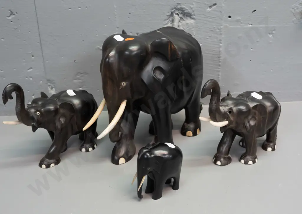 4 carved ebony elephants, varying styles - largest has crack through middle, one is missing eyes, one missing a tusk. Image 1++