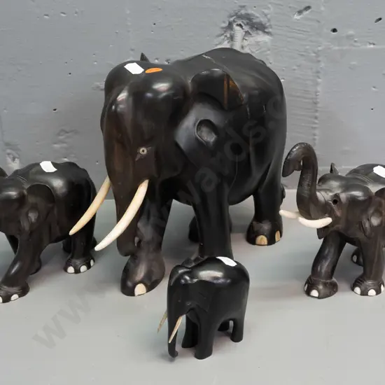 4 carved ebony elephants, varying styles - largest has crack through middle, one is missing eyes, one missing a tusk.