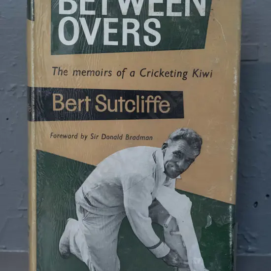 autographed hard cover book - Between Overs, signed by Bert Sutcliffe - see photo for details - some damage &