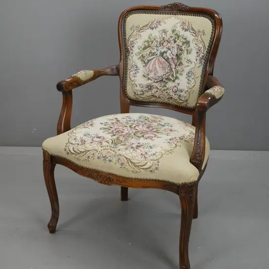 beech French style open armed chair with floral carving to back and arms, brass studded tapestry upholstery. Minor wear
