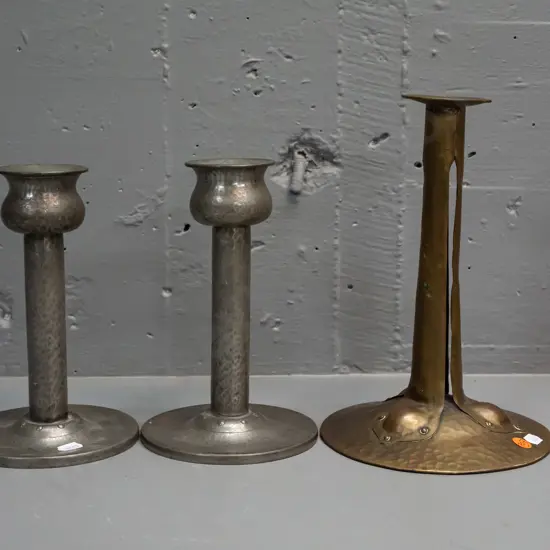 3 English hand-beaten candlesticks - pair of pewter marked Homeland and one brass one H-250. Smaller pair have holes /