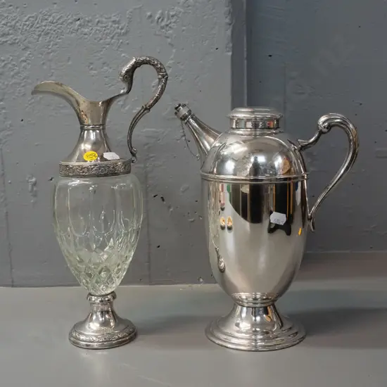 Italian glass and silver plated claret jug H-310 and a plated hot water jug with stoppered spout. Claret jug missing