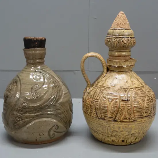 2 heavy studio pottery stoppered jugs - handled and incised gold and brown with unknown "R" maker's mark and unusual