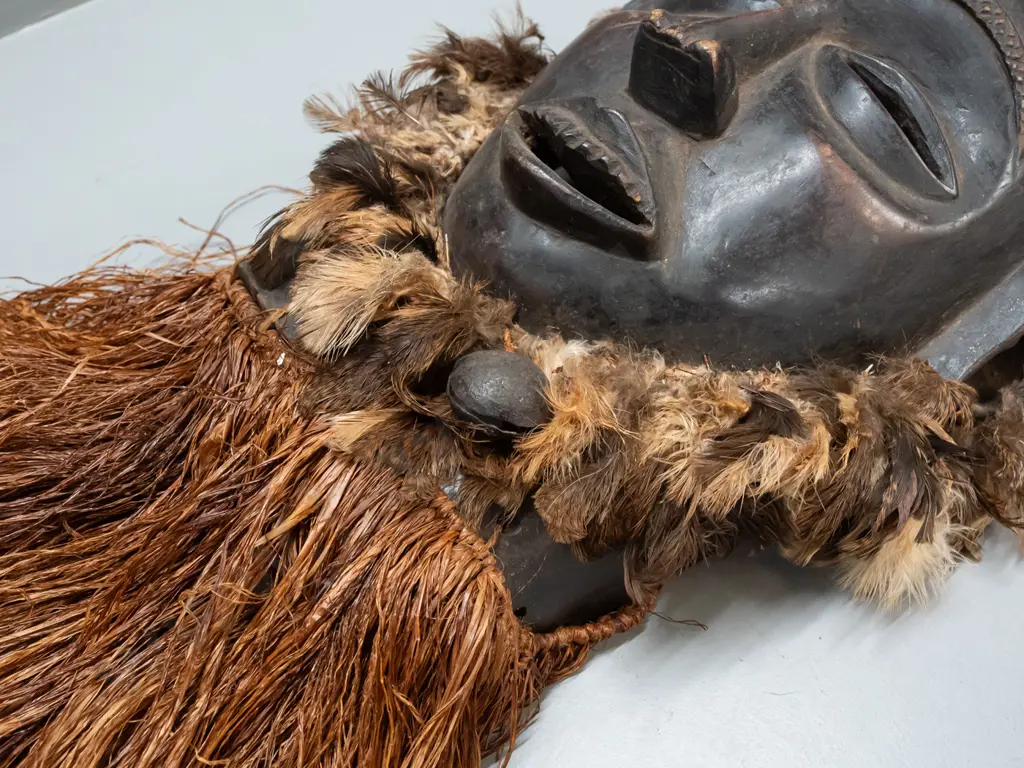 African carved wood mask with fibre and feather decoration & metal bell. Chokwe, Democratic Republic of Congo H-820 Image 1++