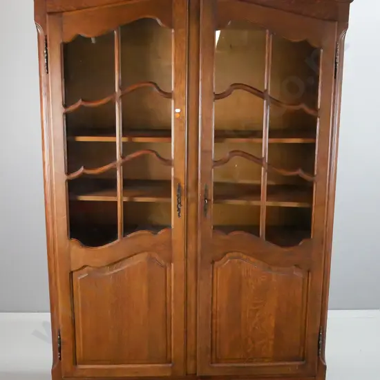 French oak 2-door cupboard with 2 astragal glazed doors, shaped door panels, and short cab legs, carved decoration and